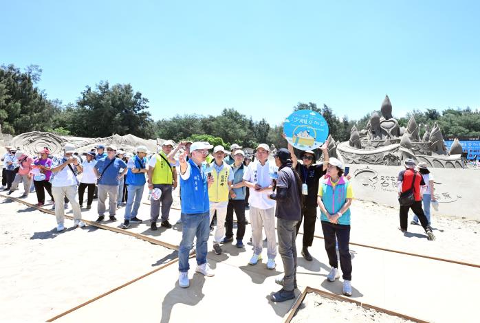 活動開幕導覽人員站在沙雕展區增設的友善木棧道上